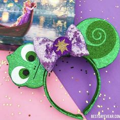 the green mouse ears are decorated with purple and gold sequins, along with an image of disney's princess