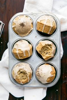 a muffin tin filled with cupcakes covered in frosting