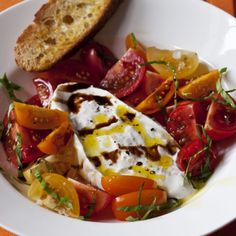 a white plate topped with lots of different types of food next to a knife and fork