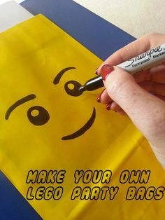 a hand holding a marker near a yellow bag with a smiley face drawn on it