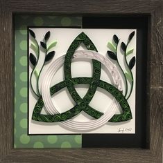 an intricate paper art piece in a wooden frame