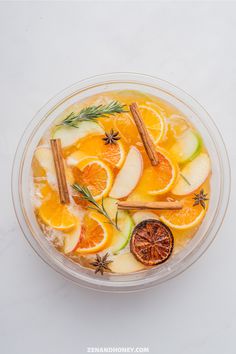 a bowl filled with orange slices and cinnamon sticks