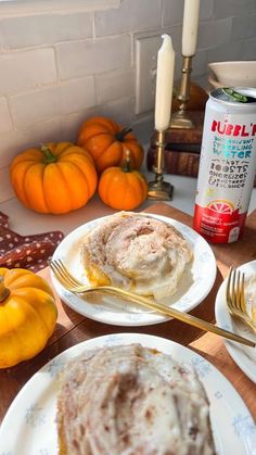 a table topped with plates of food next to pumpkins and other autumn decorating items