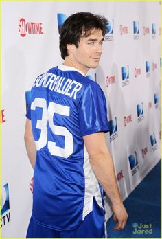 a black and white photo of a man in a football jersey on the red carpet