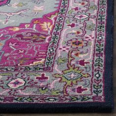 a pink and blue rug on top of a wooden floor