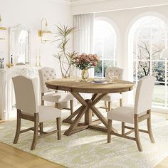 a dining room table with white chairs around it