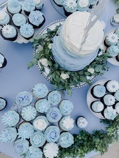 a table topped with blue and white cupcakes