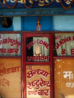 an old store front with many signs on the side and windows that say, we come to india & bangladesh