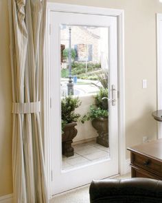 a living room filled with furniture next to a window covered in curtains and drapes