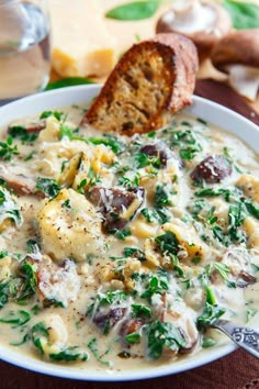 a white bowl filled with food next to bread