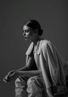 a black and white photo of a woman sitting on a chair