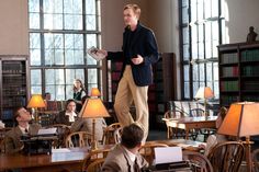 a man standing on top of a table in a library