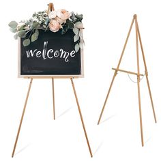 an easel with a welcome sign and flowers on the front is standing next to another easel