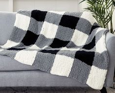 a gray couch with a black and white checkered blanket