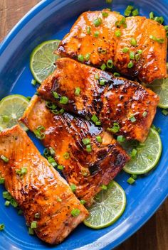 grilled salmon with limes and scallions on a blue plate