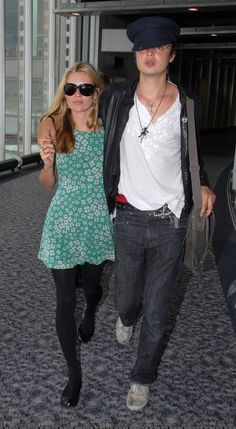 a man and woman walking through an airport