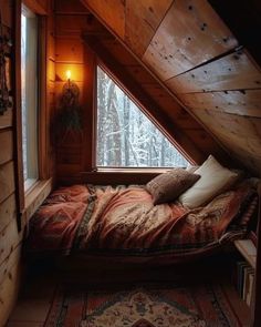 an attic bedroom with a bed in the corner and a rug on the floor next to it