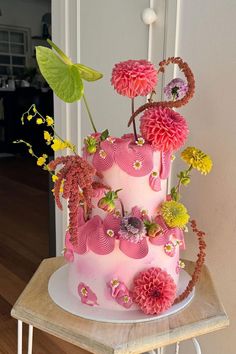 a pink and yellow cake with flowers on top