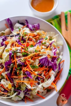 a white bowl filled with coleslaw and carrots on top of a table