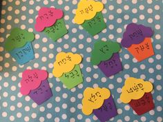 colorful cupcakes with numbers on them sitting on a polka dot tablecloth,