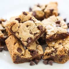 chocolate chip cookie bars cut in half on a green and white checkered napkin with a glass of milk