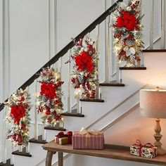 christmas decorations on the banisters and stairs in a home decorated with red poinsettias