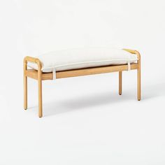 a wooden bench with a white cushion on it