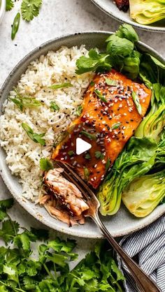 two plates filled with salmon and vegetables on top of white rice, garnished with sesame seeds