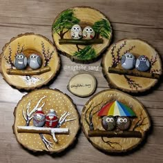 four wood slices with owls on them and one has an umbrella in the center, while three are sitting on top of each other