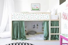 a child's bedroom with a bunk bed and green drapes on the curtains