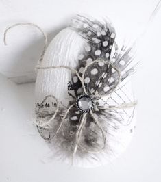 a white object with black and white feathers on it's side, next to a ball of twine