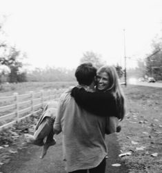 a man and woman walking down a dirt road