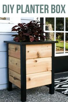 a wooden planter box sitting on top of a black and white rug next to a window