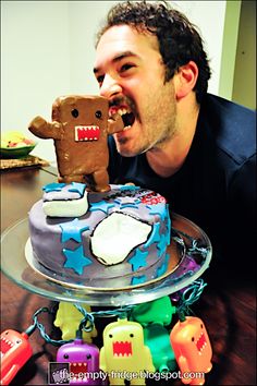 a man eating a cake with a giant ginger bear on top