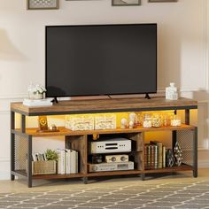 a flat screen tv sitting on top of a wooden entertainment center next to a wall