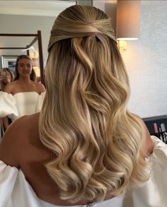 the back of a woman's head with blonde hair styled into a half - updo