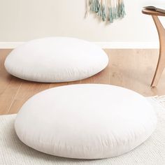 two white pillows sitting on top of a wooden floor