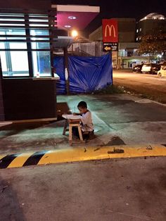 a person sitting on a bench in front of a mcdonalds sign with the caption if it is important to you, you will find a way