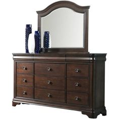 a dresser with a mirror and vases on it