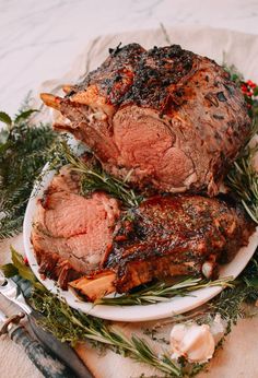 two pieces of meat on a plate with herbs