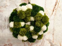 a green and white wreath on a marble wall