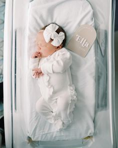 a baby is laying down in a clear case with a tag on it's side