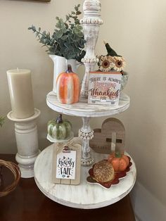 three tiered tray with pumpkins and other decorations