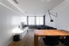 an empty room with a wooden table and black chairs