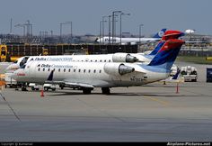 two airplanes are parked on the tarmac at an airport with other planes in the background