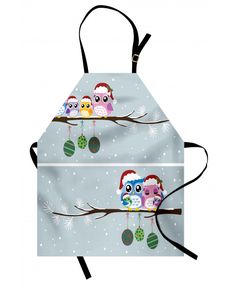 two aprons with owls sitting on a tree branch in the snow, one has an ornament hanging from it