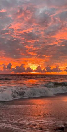 the sun is setting over the ocean with clouds in the sky and waves on the beach