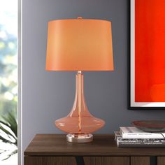 a lamp on a table next to a painting