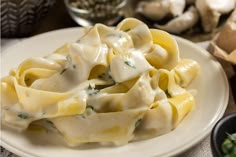 a white plate topped with pasta covered in sauce