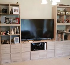 a living room with shelves and a flat screen tv on it's stand in front of the wall